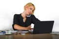 Corporate business portrait of young beautiful and busy woman with blonde hair working at office laptop computer desk talking on m Royalty Free Stock Photo