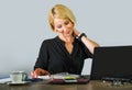 Corporate business portrait of young beautiful and happy woman with blonde hair smiling while working relaxed at office laptop com Royalty Free Stock Photo