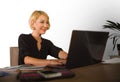 Corporate business portrait of young beautiful and happy woman with blonde hair smiling while working relaxed at office laptop com Royalty Free Stock Photo