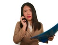 Corporate business stress portrait of young attractive upset and stressed executive Asian Chinese woman talking on mobile phone Royalty Free Stock Photo