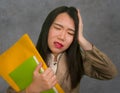 Corporate business stress portrait of young attractive upset and stressed executive Asian Chinese woman tired and unhappy holding Royalty Free Stock Photo