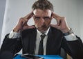 Corporate business work stress - young desperate and frustrated businessman working stressed and overwhelmed at office computer Royalty Free Stock Photo