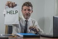 Corporate business worker in stress -  attractive stressed and desperate businessman holding sign crying for help overworked and Royalty Free Stock Photo