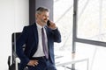 Corporate Communication. Middle Aged Businessman Wearing Suit Having Mobile Call In Office Royalty Free Stock Photo