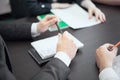 Corporate decision making. A group of businessmen shows and discusses something while colleagues are listening, sitting at a table