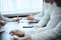 Corporate decision making. A group of businessmen shows and discusses something while colleagues are listening, sitting at a table