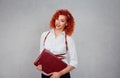 Corporate employee, worker. Portrait of a cute attractive young red head business woman in formal shirt holding brown bag smiling Royalty Free Stock Photo