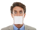 Corporate gagging. Concept studio portrait of a young businessman with a sticky note over his mouth isolated on white. Royalty Free Stock Photo