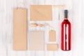 Blank brown kraft packaging, stationery, merchandise set with bottle rose wine on soft white wood background. Royalty Free Stock Photo