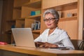 Corporate job lifestyle portrait of happy and successful attractive middle aged Asian woman working at office laptop computer desk