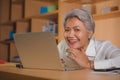 Corporate job lifestyle portrait of happy and successful attractive middle aged Asian woman working at office laptop computer desk Royalty Free Stock Photo