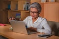 Corporate job lifestyle portrait of happy and successful attractive middle aged Asian woman working at office laptop computer desk