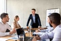 Corporate Meeting Concept. Confident Businessman Talking To Diverse Coworkers In Conference Room Royalty Free Stock Photo