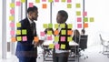 Corporate mentor teaching intern to work with sticky notes