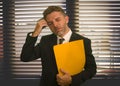 Corporate office lifestyle portrait of stressed and frustrated business man holding paperwork reports overwhelmed and upset at Royalty Free Stock Photo