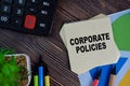 Corporate Policies write on sticky notes isolated on Wooden Table