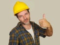 Corporate portrait of construction worker - Attractive and happy builder man in safety helmet giving thumb up smiling as Royalty Free Stock Photo