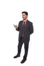 Corporate portrait of young attractive businessman of Latin Hispanic ethnicity smiling using mobile phone Royalty Free Stock Photo