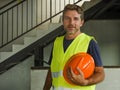 Corporate portrait of young attractive and happy builder man or constructor posing confident smiling wearing building helmet and Royalty Free Stock Photo