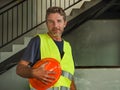 Corporate portrait of young attractive and happy builder man or constructor posing confident smiling wearing building helmet and Royalty Free Stock Photo