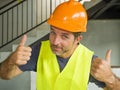 Corporate portrait of young attractive and happy builder man or constructor posing confident smiling wearing building helmet and Royalty Free Stock Photo