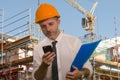 Corporate portrait of young attractive and successful engineer man or architect working on building at construction site wearing Royalty Free Stock Photo