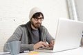 Corporate portrait young hispanic attractive hipster businessman working with computer modern home office Royalty Free Stock Photo