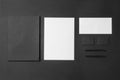 Corporate stationery set mockup. Presentation folder, letterheads and two business cards at black textured paper background Royalty Free Stock Photo