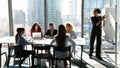 Corporate team sit by table listen to black woman presenter Royalty Free Stock Photo