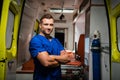 Corpsman in medical uniform look at camera and smile, ambulance car on the background