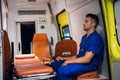 Corpsman in medical uniform sits inside the ambulance car