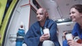 Injured man sit with nurse and corpsman, talk and smile.