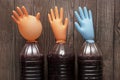 Correct fermentation process, making homemade wine. Plastic bottles with huge multi-colored inflated gloves on a wooden background Royalty Free Stock Photo