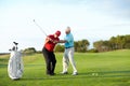 The correct technique. A male golfer getting help from his caddy on the golf course. Royalty Free Stock Photo