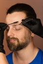 Correcting shape of eyebrows to male client Royalty Free Stock Photo