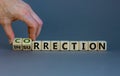 Correction vs insurrection symbol. Businessman turns wooden cubes and changes word `insurrection` to `correction`. Beautiful g