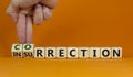 Correction vs insurrection symbol. Businessman turns wooden cubes and changes word insurrection to correction. Beautiful orange