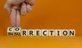 Businessman turns wooden cubes and changes word insurrection to correction. Beautiful orange