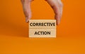 Corrective action symbol. Wooden blocks with words `Corrective action` on beautiful orange background. Businessman hand. Busines