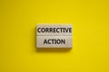 Corrective action symbol. Wooden blocks with words `Corrective action` on beautiful yellow background. Business and Corrective