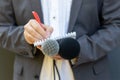 Correspondent or reporter at media event, holding microphone, writing notes. Journalism concept