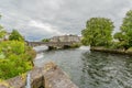 Corrib river with calm flow, the William O`Brien bridge and a small dam with water entering the river through a small waterfall Royalty Free Stock Photo