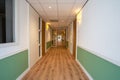 Corridor with doors on both sides. The floor is made of wood and the walls are white Royalty Free Stock Photo