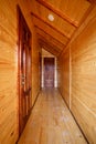 Corridor with doors of different rooms in a wooden cottage.