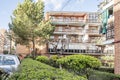 Corridor between hedges and gardens with leafy trees in common areas of an urbanization of urban buildings with brick facades and Royalty Free Stock Photo