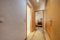 Corridor of a house with white painted walls with gotelet, classic furniture, long carpet on the floor and built-in cabinets on