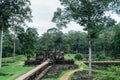 A corridor made in the middle of the garden and many stones thrown on the ground of the ruins of Ankgor Thom in Cambodia - World