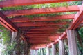 Corridor surrounded by columns and under red pergola in park Royalty Free Stock Photo