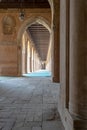 Corridor surrounding the courtyard of the public mosque of Ahmad Ibn Tulun framed by huge decorated arches, old Cairo, Egypt Royalty Free Stock Photo