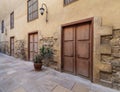 Corridor with weathered stone bricks wall and row of grunge wooden aged decorated doors and windows Royalty Free Stock Photo